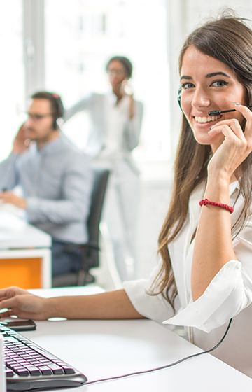 A woman on a headset at her desk