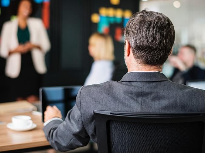 man in a meeting on his computer