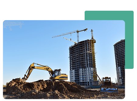 A yellow tractor on a construction site with a building in the background