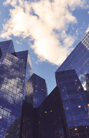 Glass Office Buildings Downtown Blue Sky with Clouds - net2phone Canada - Business VoIP Phone System