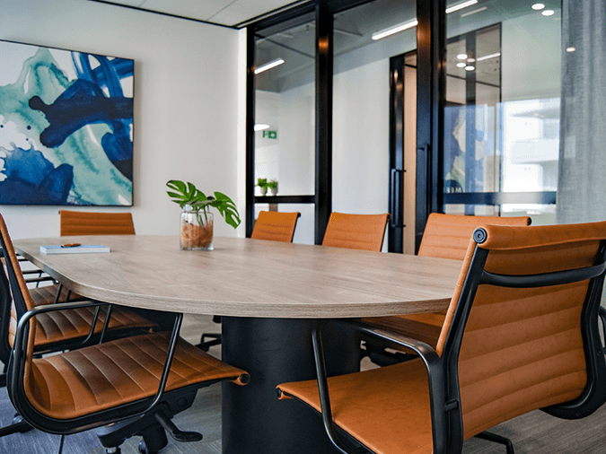 Naidu Legal - Big conference table with leather chairs and blue painting - net2phone Canada - Business VoIP Phone System