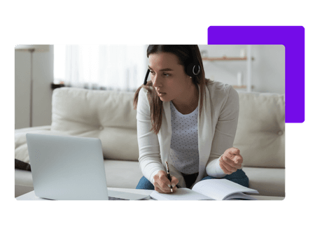 woman working from home wearing headset writing in notebook in front of lap top - net2phone Canada - Business VoIP Phone System