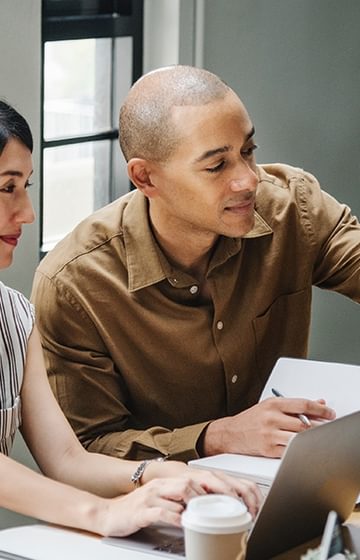 new employee welcome pack man and woman work together on laptops