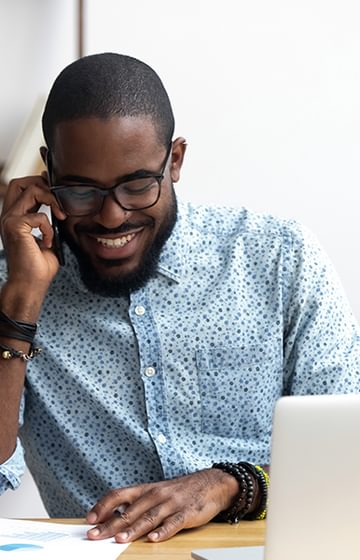 A man talking on the phone at his desk