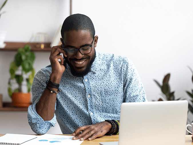 A man talking on the phone at his desk