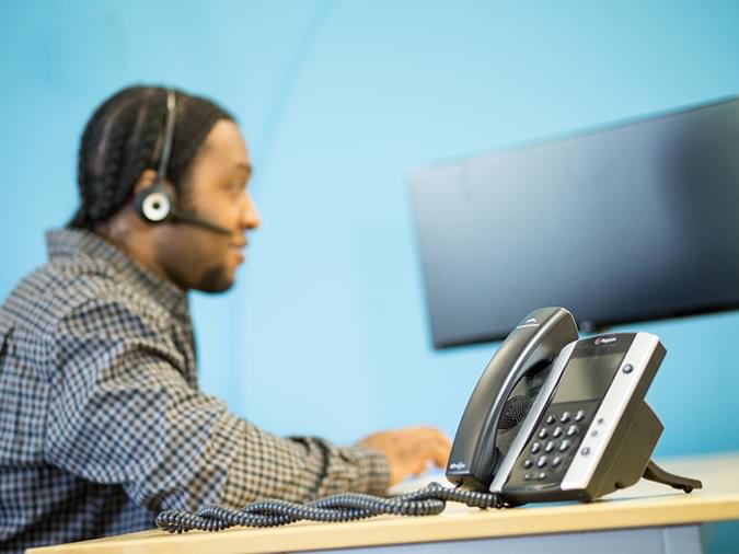 net2phone canada employee on a poly phone and headset