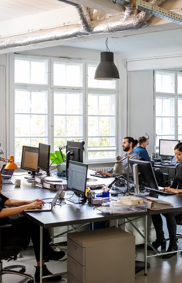 Employees working on computers in modern office space - net2phone Canada - Business VoIP Phone System