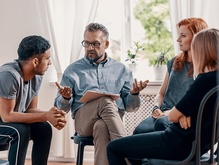 Man with notebook having a circle meeting with other people - net2phone Canada - Business VoIP Phone System