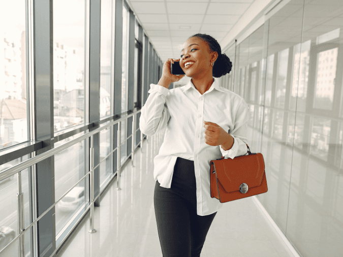 A woman walking down a hallway talking on the phone