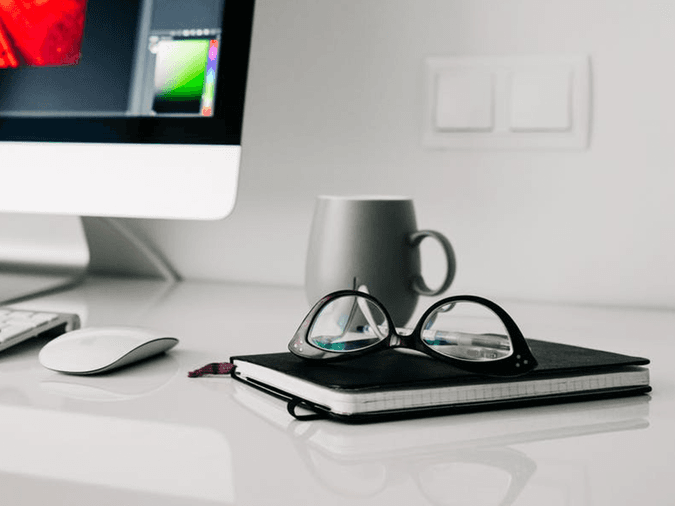 Eye Care pros - glasses on notebook on desk with apple desktop - net2phone Canada - Business VoIP Phone System