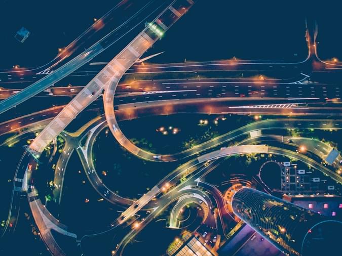aerial time-lapse night traffic on a busy city highway interchange