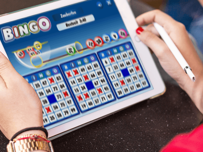 Bingo on ipad held by woman - net2phone Canada - Business VoIP Phone System