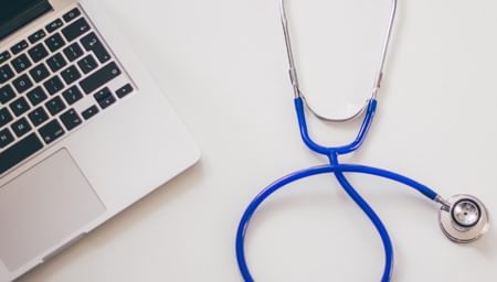 Stethoscope beside a computer