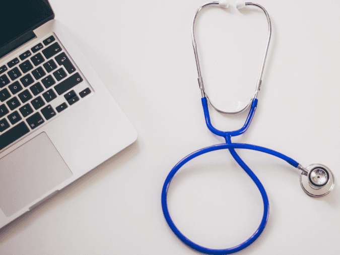 Stethoscope beside a computer