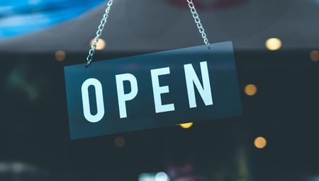 Picture of an open door sign hung from the entrance of a store