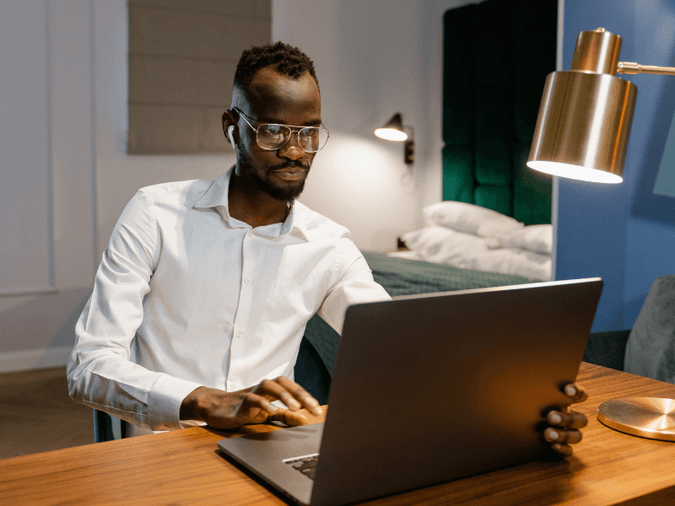 Man working remotely from a desk in his bedroon