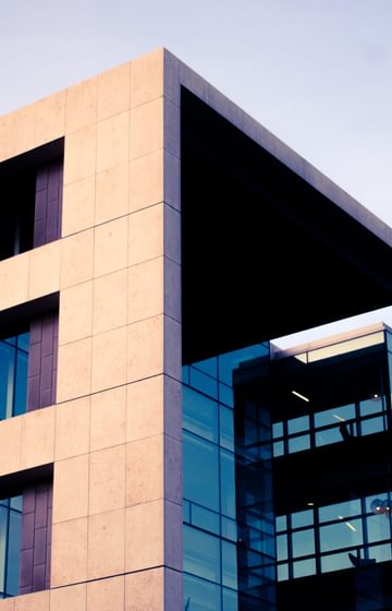 outside top corner of a modern concrete office building with large windows