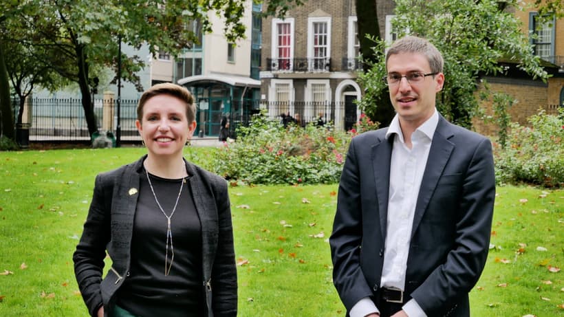 Woman and man in business suites standing in front of lawn