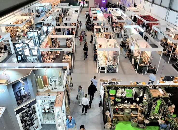Aerial shot of an event hall filled with exhibition stands and people walking down the aisles