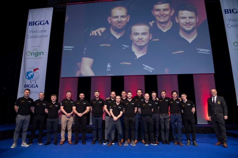 A group of men posing in front of a large screen at Harrogate Convention Centre