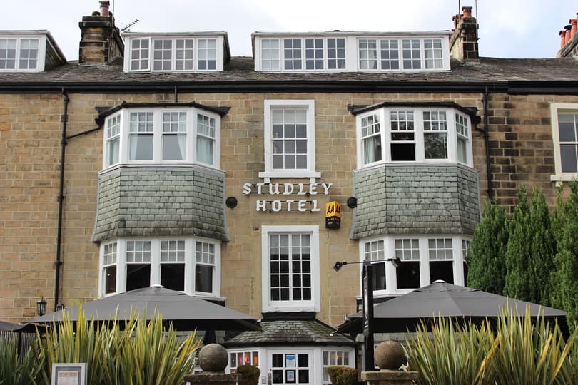 A 4-story building with the sign Studley Hotel