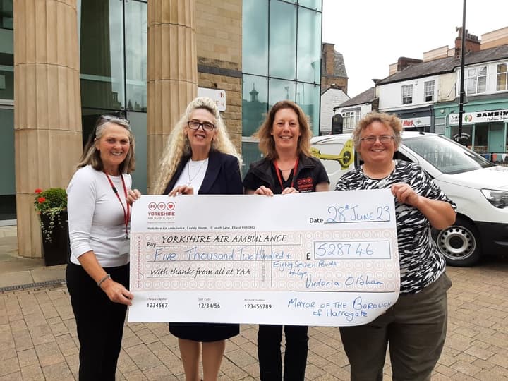 4 ladies holding an oversized charity cheque of a donation of £5287.46 from Victoria Oldham to Yorkshire Air Ambulance