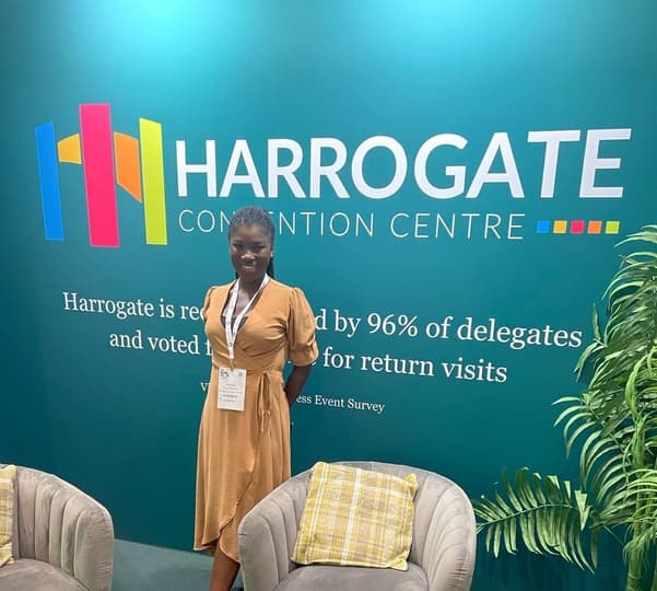 Woman standing in front of a Harrogate Convention Centre backdrop