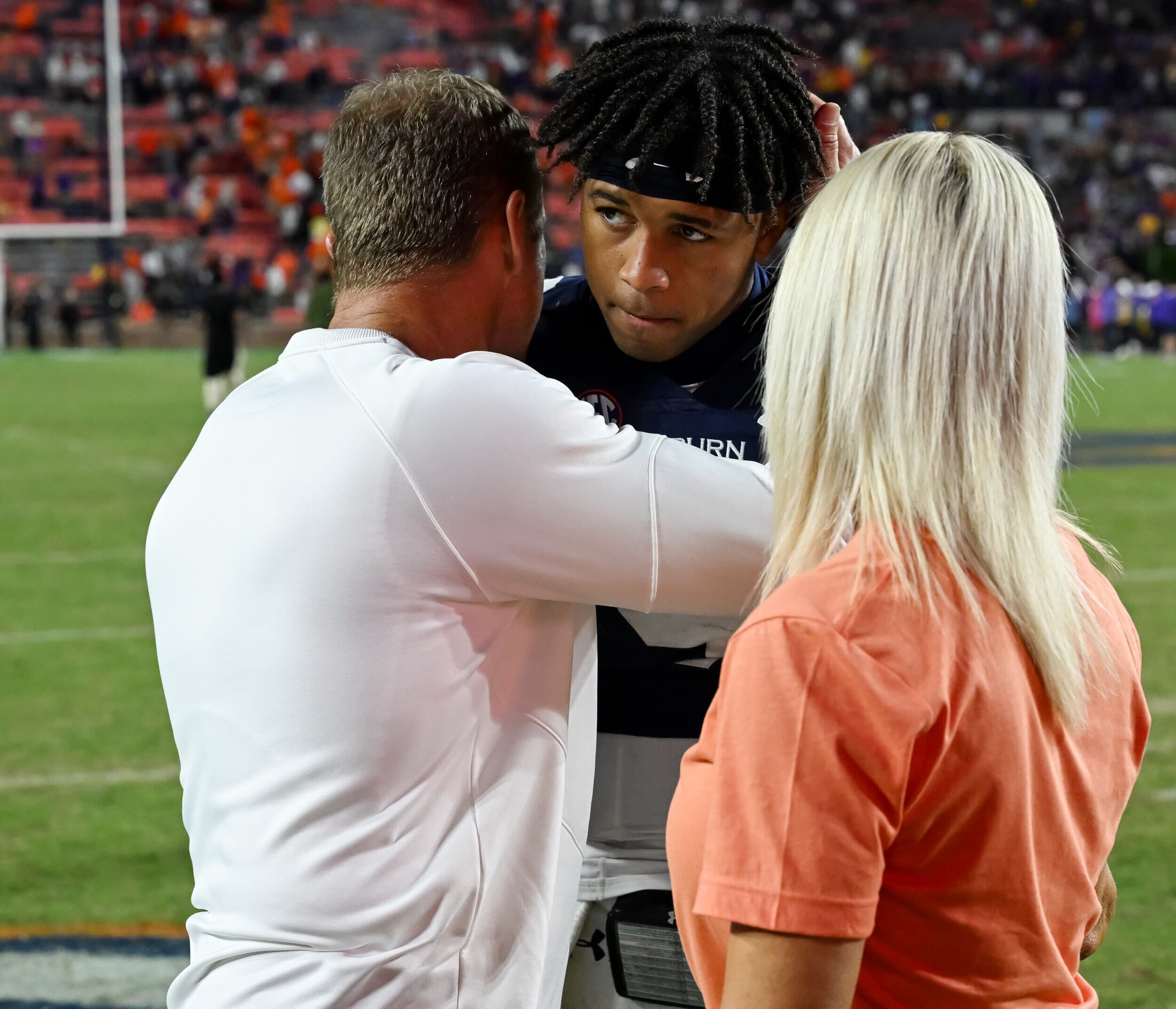 Coach Bryan Harsin hugs Robby Ashford and wife Kes Harsin after the game on Saturday, Oct. 1, 2022 in Auburn.