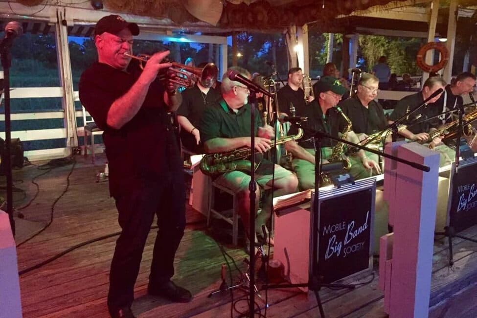 Attorney Chip Herrington, conductor of Mobile Big Band, blows trumpet solo at Bluegill on the Causeway.  Second from left is Federal Judge William Steele, a saxophonist.