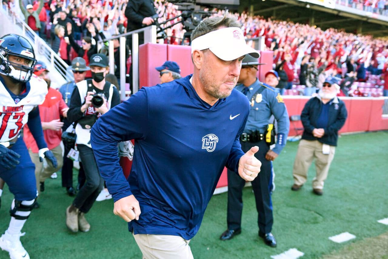 Liberty head coach Hugh Freeze leads his team onto the field to play Arkansas during an NCAA college football game Saturday, Nov. 5, 2022, in Fayetteville, Ark.