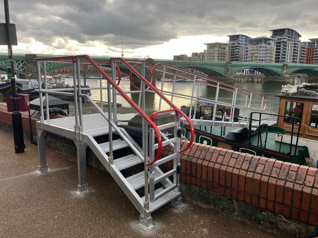 Image of a gangway with a platform allowing access to a boat house by Alloy Ramps.