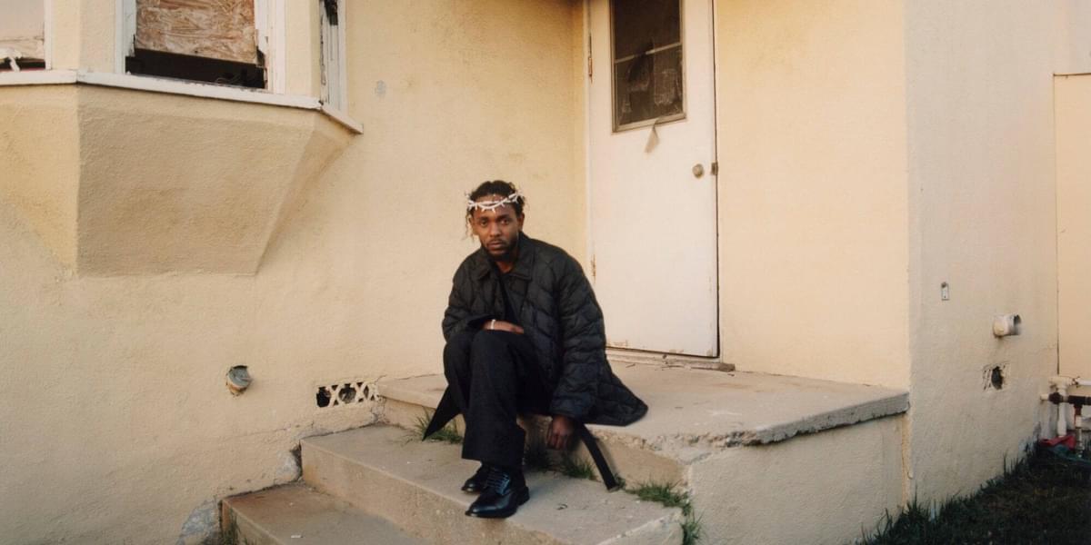 Kendrick Lamar sitting on front porch steps with thorn crown