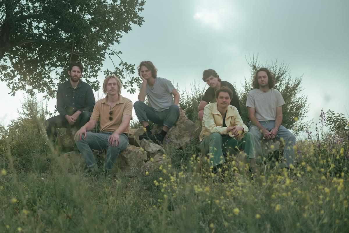 King Gizzard and the Lizard Wizard sitting on rocks for "Ice V" single