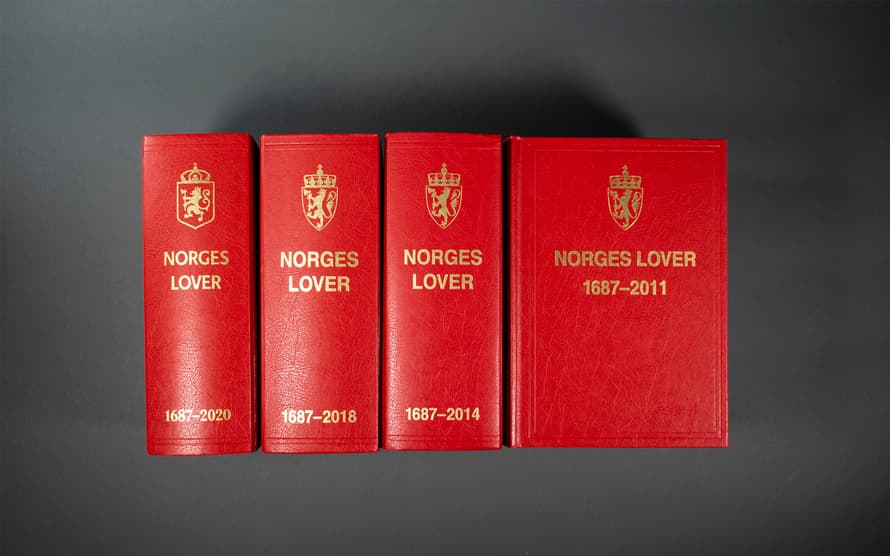 Bildet viser fire versjoner av Norges lover. Vi ser ryggen på tre av dem, og forsiden på den siste versjonen. På omslaget er et et emblem og tittelen "Norges lover" etterfulgt av årstallene 1687–2011"