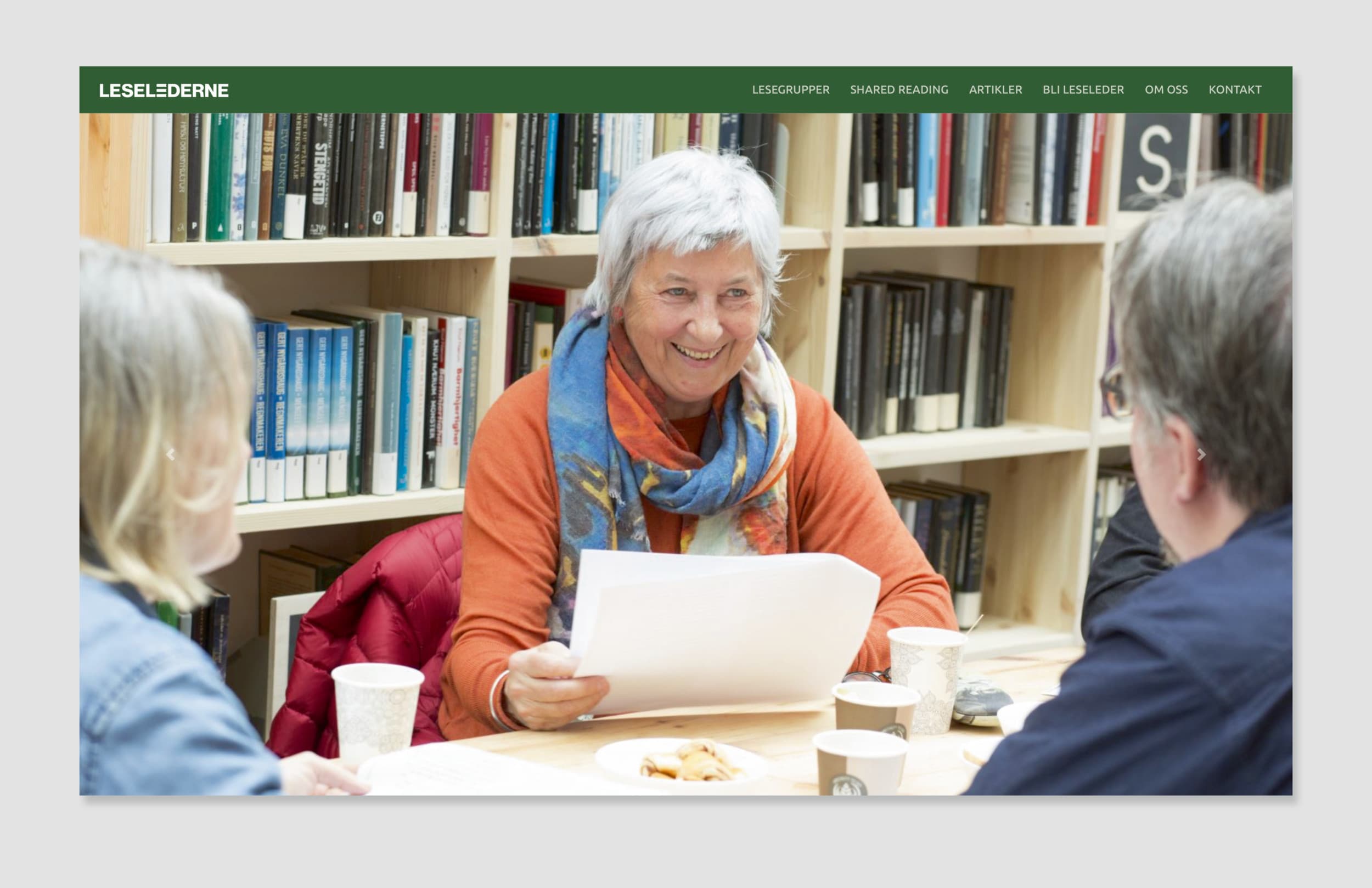Bildet viser et utsnitt av nettsiden til Leselederne. Menyen er grønn, med hvit skrift. Øverst er et stort bilder. Det viser 3 personer som sitter rundt et bord.