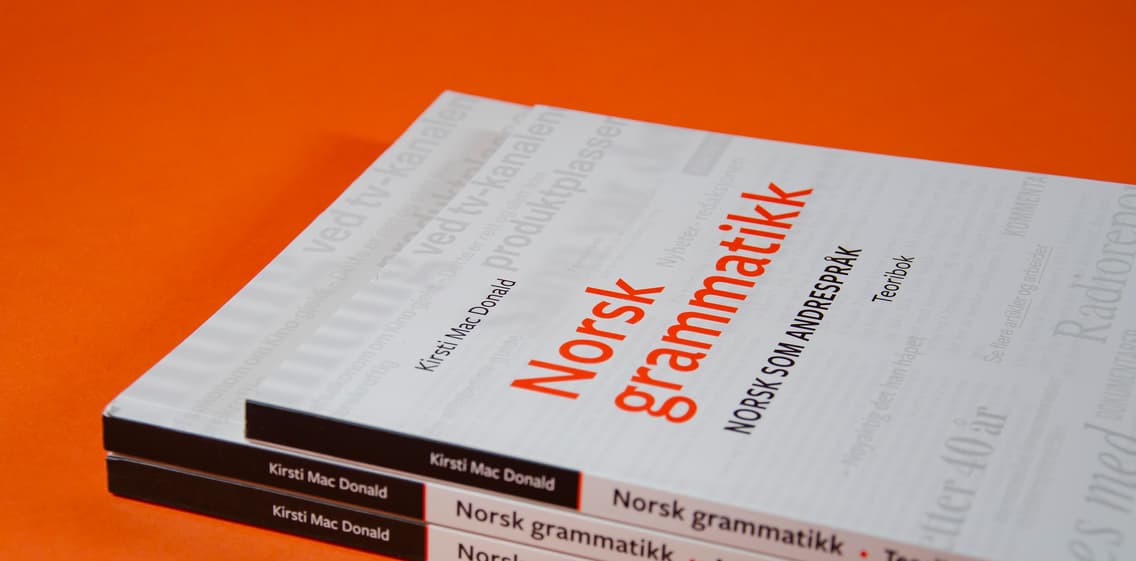 Bildet viser en stabel av arbeidsbøkene og teoriboken til Norsk grammatikk