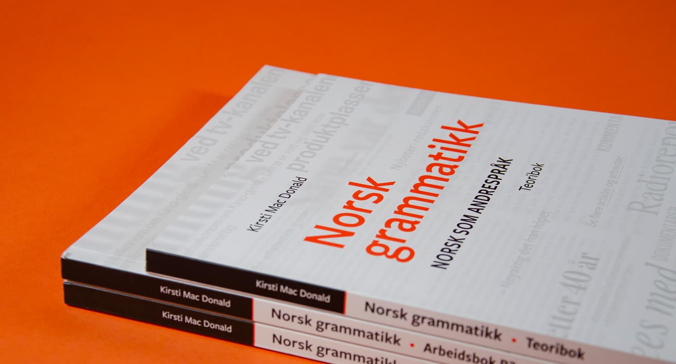 Bildet viser en stabel av arbeidsbøkene og teoriboken til Norsk grammatikk