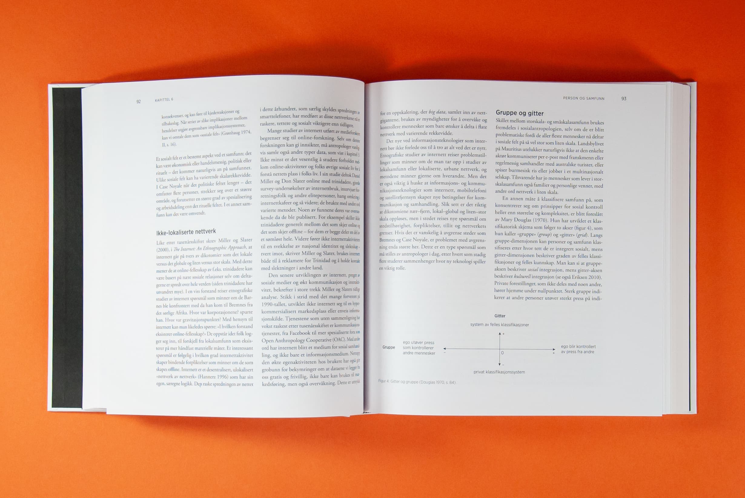 Bildet viser et oppslag av en bok, tatt ovenfra. Det er tekst i to spalter på hver side. Nederst på høyre side er det en liten figur.