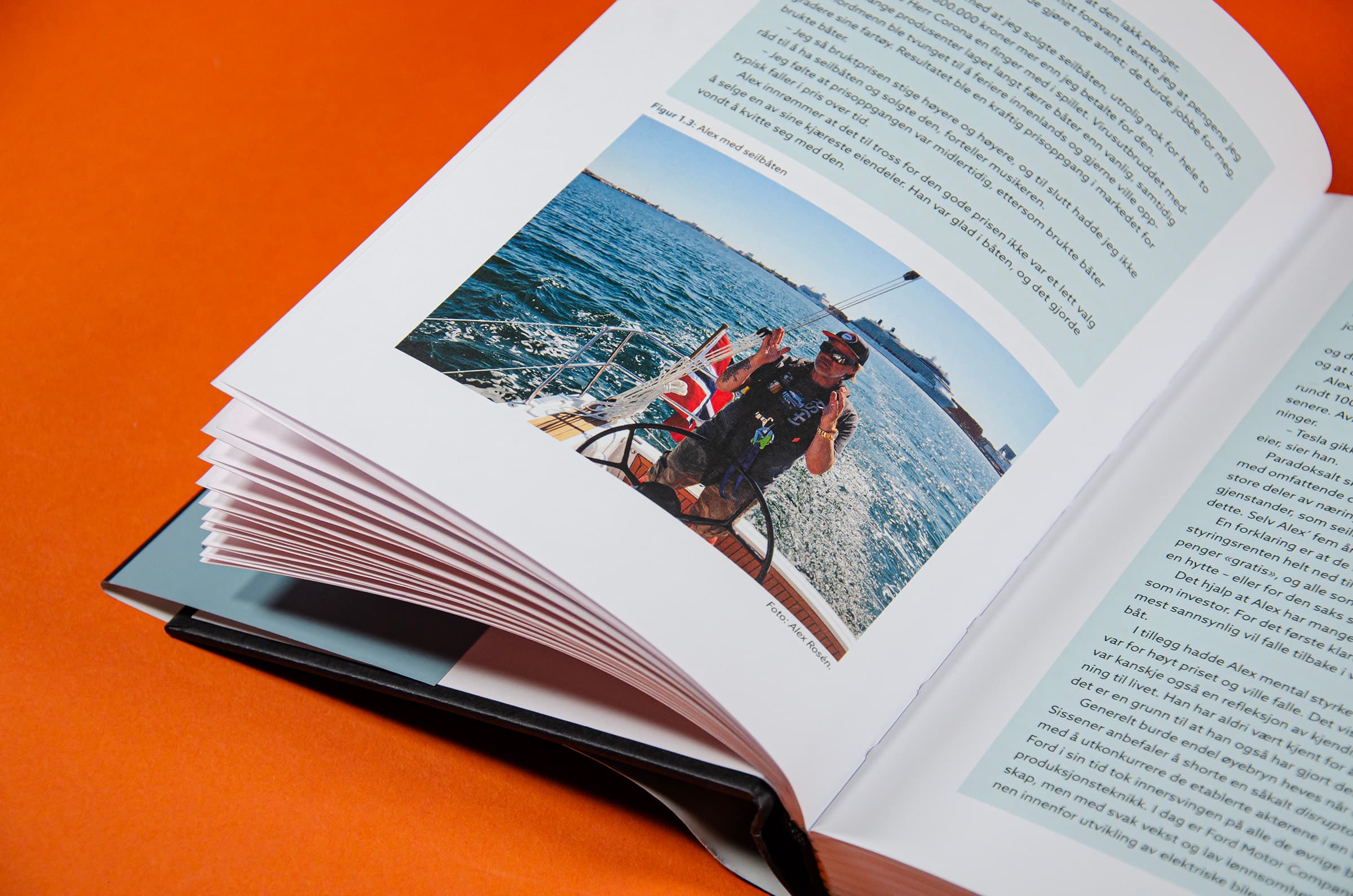 Bildet viser et utsnitt av en bok. Det er blå tekstbokser på siden. Nederst på venstre side er det et bilde av Alex Rosén i en seilbåt.