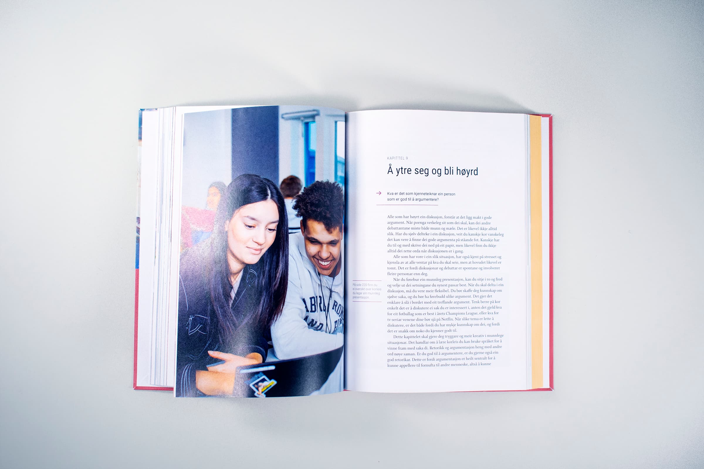 Bildet viser hvordan en kapittelstart i boken ser ut. På venstre side er det et bilde av to personer som ser på en skjerm sammen, og på høyre side er det en kapitteltittel og brødtekst.