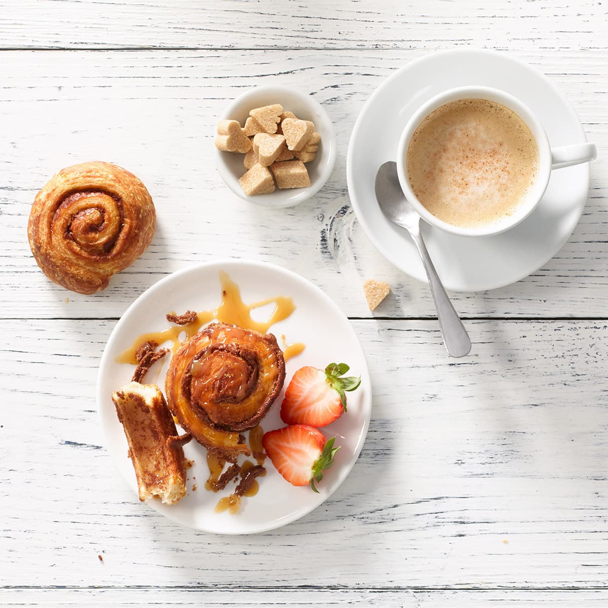 two mini decadent cinnamon buns with coffee and sugar squares