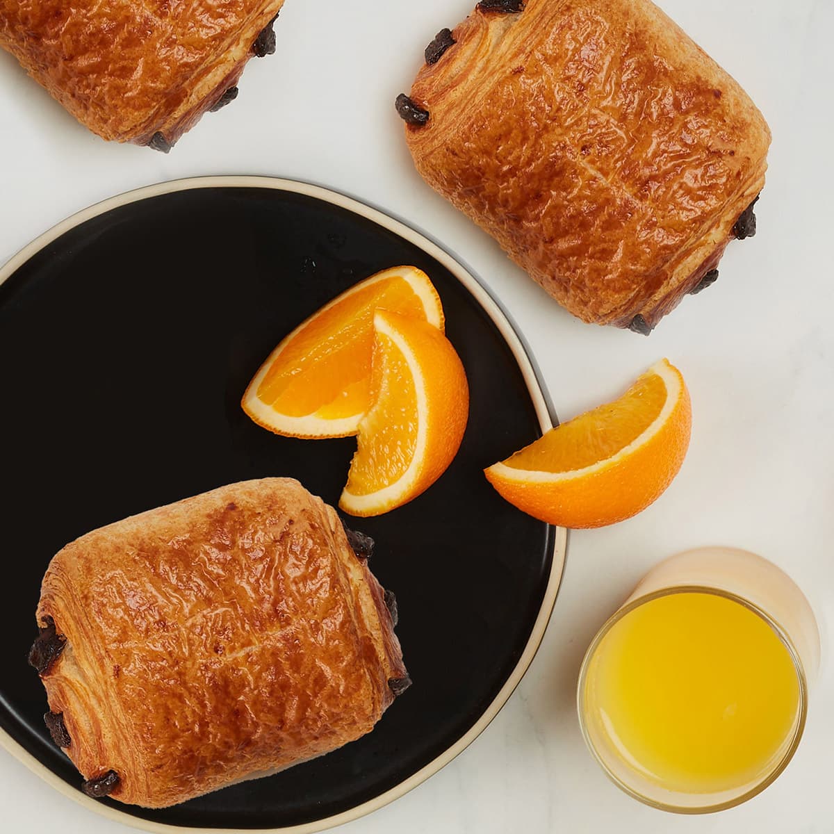 trois chocolatines parfaites beurre et un jus d'orange