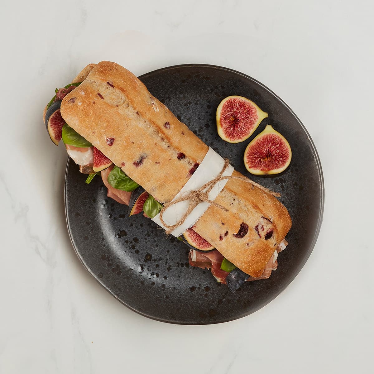 sliced cranberry baguettine sandwich with two figs