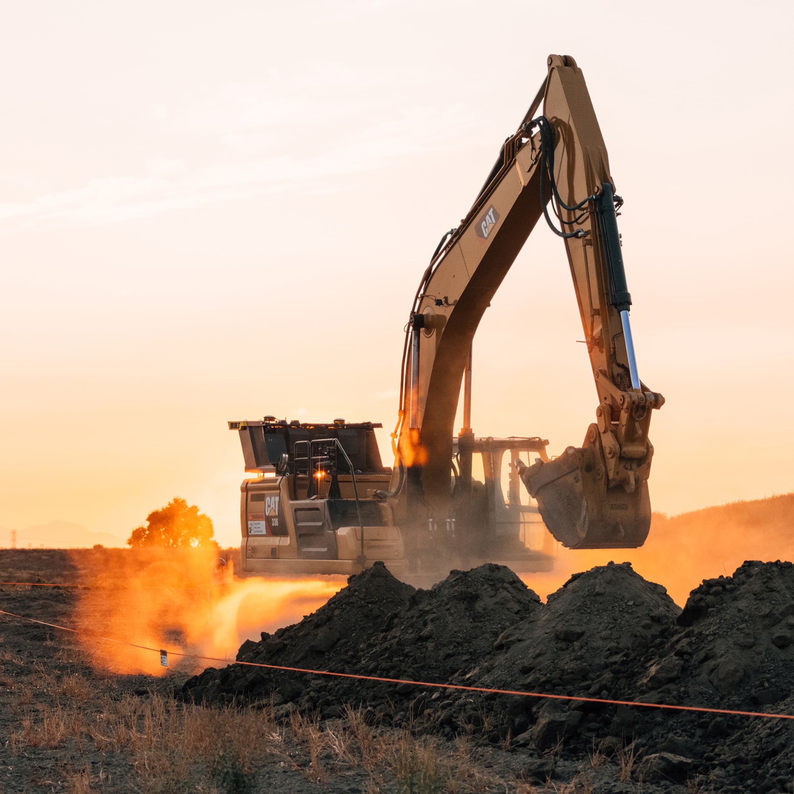 Excavator digging dust sunset