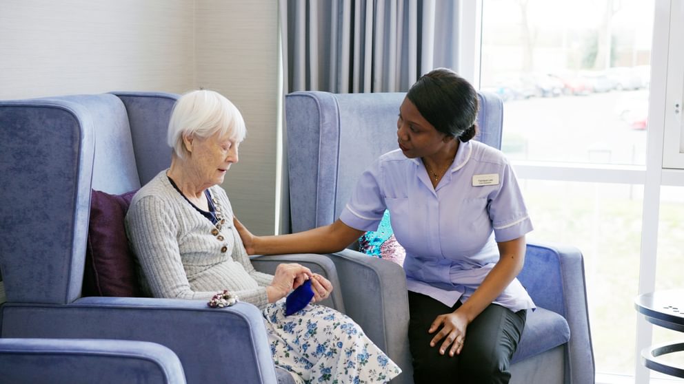 A registered nurse at a dementia specialist care home assisting a resident.