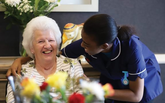 Member of staff at Caring Homes care home caring for elderly resident