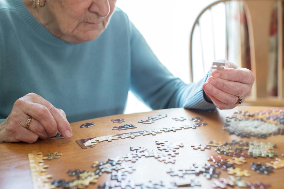 Elderly resident at a care home completing a puzzle