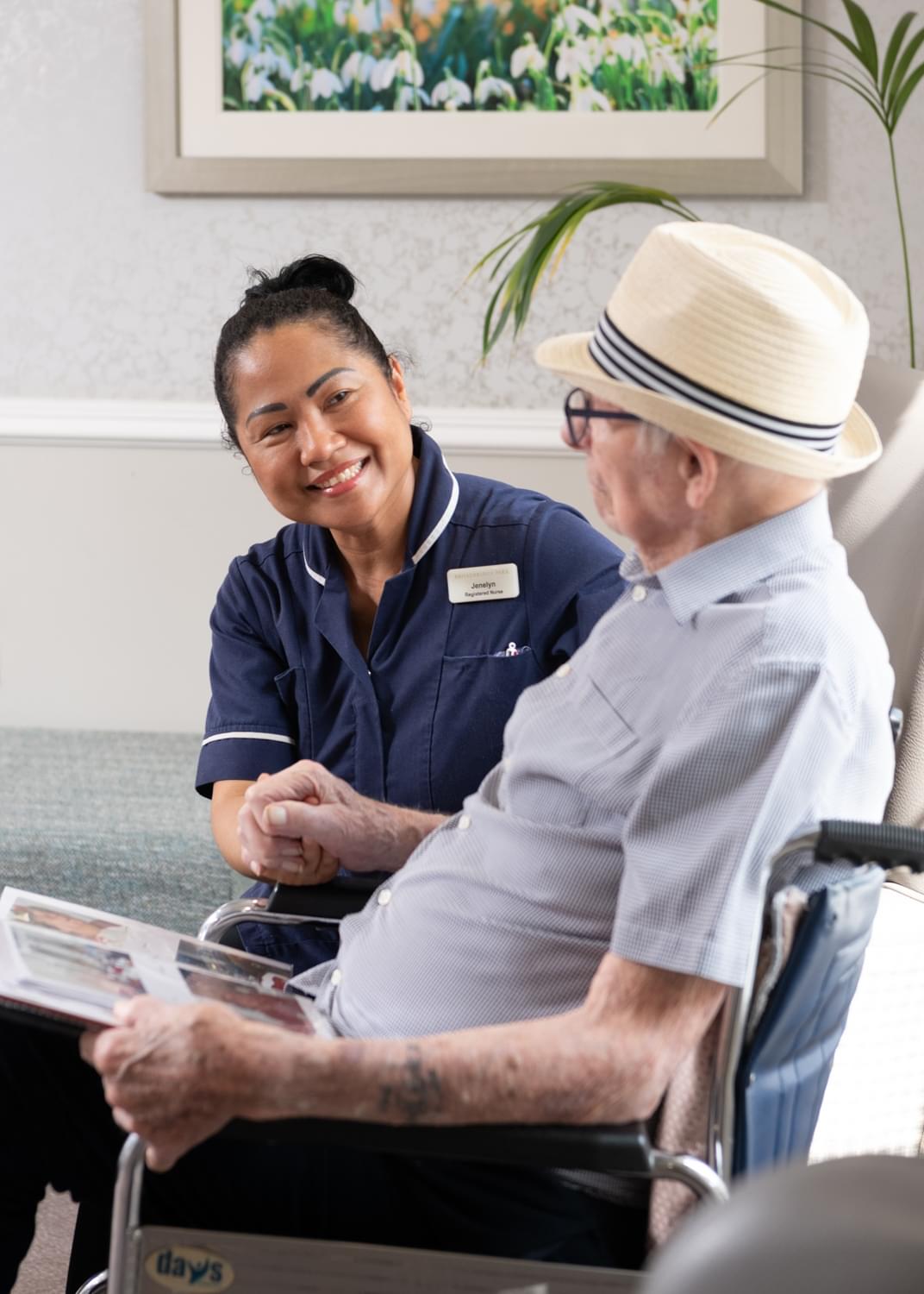 Nurse with resident looking at photo album side profile