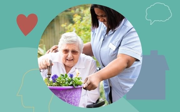 A resident at a dementia care home gardening with the help of a registered nurse.
