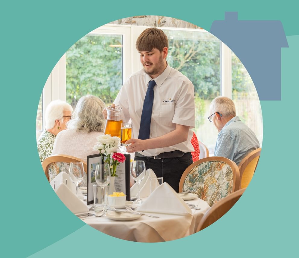 A team member at Caring Homes serves breakfast to dementia care home residents.